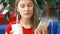 Woman in red t-shirt sitting in cafe using her smartphone, listening music drinking cola from paper cup