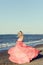 Woman in red tulle dress dancing at the beach