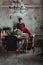 Woman in red vintage dress sits on the table served for christmas diner. Loft interior with clear concrete wall