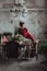 Woman in red vintage dress sits on the table served for christmas diner. Loft interior with clear concrete wall