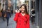 Woman in red walking talking on phone in winter