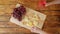 Woman with red wine eating cheese. Grapes and cheese on a wooden table.