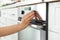 Woman regulating cooking mode on oven panel in kitchen,