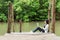 Woman relax and chill while listening music with headphone and laptop in the outdoor education nature green park, girl happy.