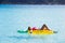 Woman relaxes on inflatable mattress over turquoise water during a tropical island vacation