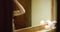 Woman relaxing in bathroom. Woman relaxation wearing towel. Relaxed woman looking at mirror