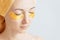 Woman relaxing with closed eyes and hydrogel golden patches.