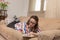 Woman relaxing on comfortable couch alone, holding paper book