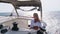 woman relaxing on a cruise catamaran sail boat wearing white summer dress