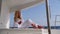 woman relaxing on a cruise catamaran sail boat wearing white summer dress