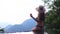 Woman relaxing at the edge of infinity swimming pool at resort rubber ring hills and mountain view