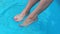 Woman relaxing foot in blue water