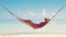 Woman relaxing in a hammock on tropical island beach. Summer exotic vacation.