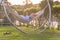 Woman relaxing with her mobile phone in a hammock