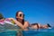 Woman relaxing on inflatable air mattress at turquoise water