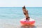 Woman relaxing with inflatable ring on the beach. shocked or surprise girl in the cold sea. Summer holidays and vacation concept