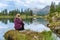 Woman relaxing near by beautiful lake Federa in Dolomites Italy