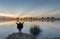 Woman relaxing at riverside before sunrise