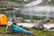 Woman relaxing in sleeping bag on mat enjoying lake