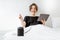 Woman relaxing with a smart speaker and tablet in the bedroom