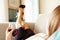 Woman Relaxing On Sofa With Glass Of Wine After Work