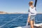 Woman relaxing on a summer sailin cruise, sitting on a luxury catamaran, standing in Maddalena Archipelago, Sardinia