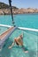 Woman relaxing on a summer sailing cruise,lying in hammock of luxury catamaran near picture perfect white sandy beach on