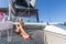 Woman relaxing on a summer sailing cruise, sitting on a luxury catamaran near picture perfect Palau town, Sardinia