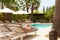 Woman Relaxing On Sun Lounger By Hotel Swimming Pool