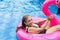 Woman relaxing in the swimming pool, using a floater