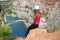 Woman relaxing on a top of canyon in Czech Republic. Making selfie. Traveler lifestyle. Woman with bag and hat.