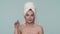 A woman removes hydrogel patches from the skin under her eyes. Portrait of a woman with a towel on her head in the