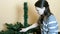 Woman removes the lower branches of an artificial Christmas tree.