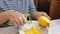 The woman removes the zest from the lemons.