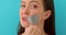 Woman removing adhesive tape from mouth