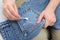 Woman removing chewing gum from jeans, closeup