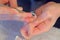 Woman is removing gel polish shellac from nails using pusher, manicure at home.