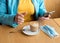 Woman removing the mask, drinking coffee and chating in the cafe during lockdown