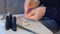 Woman removing shellac from nails using pusher and file, manicure at home.