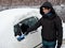 Woman removing snow from car