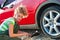 Woman repairing a car, unscrew the wheel