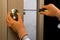 Woman repairing door handle close up. Women home service concept. Hand holding screwdriver.