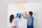 Woman And Repairman Collecting Water From Ceiling