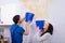 Woman And Repairman With Collecting Water From Damaged Ceiling