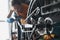 Woman repairman in rubber gloves repairing bike with tools closeup