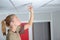 Woman replacing bulb in overhead spotlight