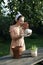 A woman replants an impatiens in a new pot