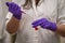 A woman researcher adding toxic reagent carefully in a chemistry laboratory wearing gloves and lab coat