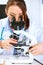 Woman researcher using microscope in laboratory.