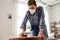 woman in respirator sanding old table with sponge